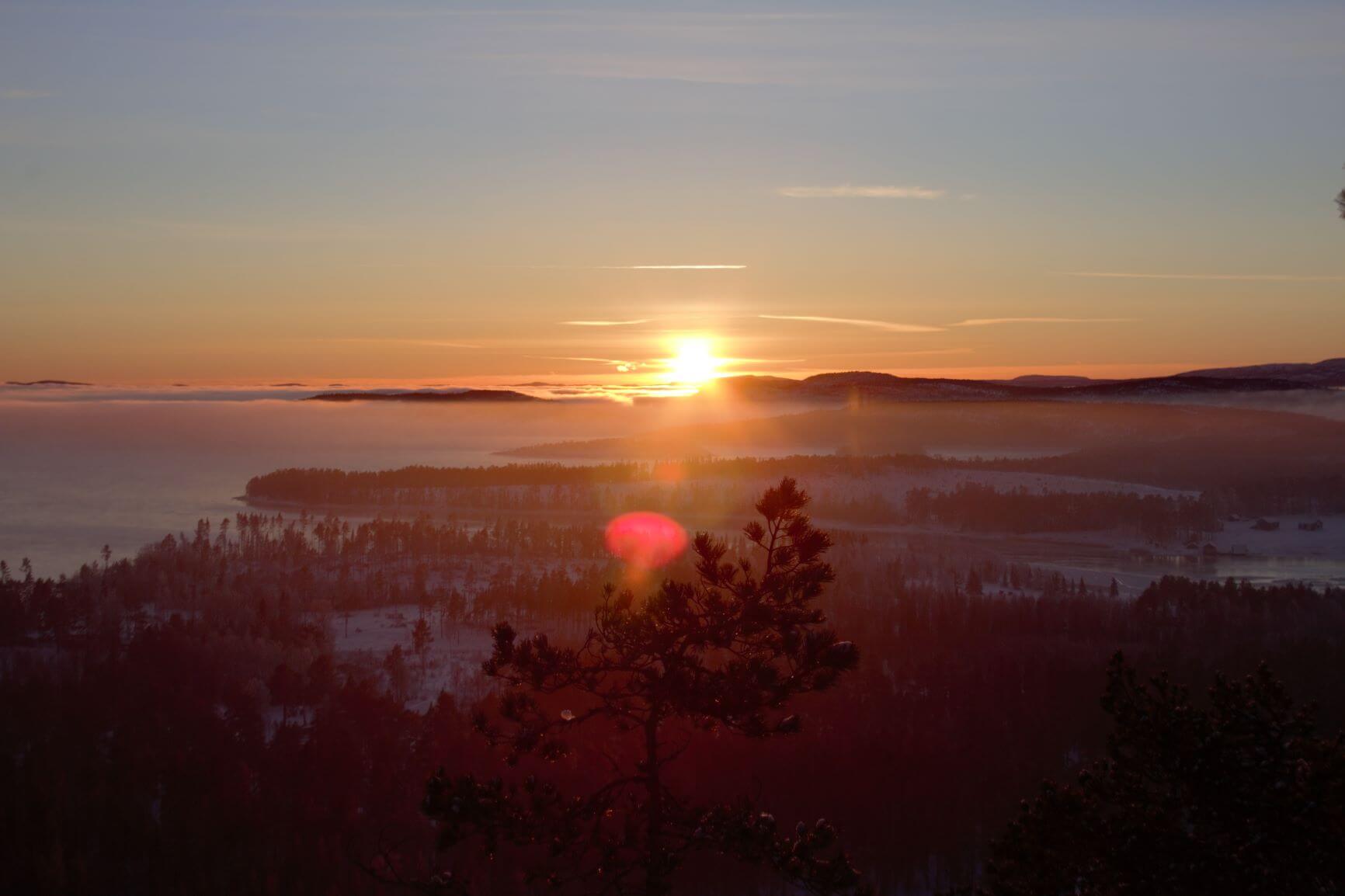 Widok na zachodzące słońce w zimowy dzień na Wysokim Wybrzeżu w Szwecji.