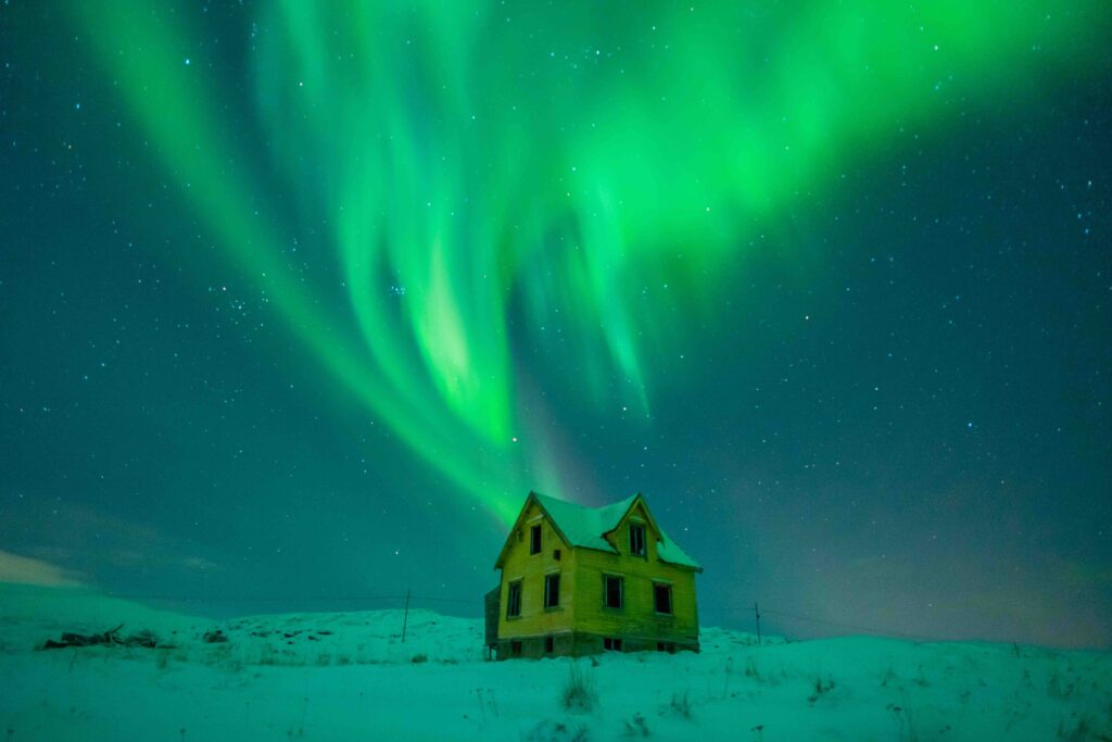 Zorza polarna na tle starego domku w Norwegii.